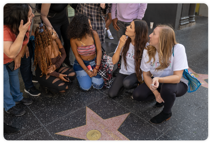 A tour group kneeling in front of Marilyn Monroe's Walk of Fame star.